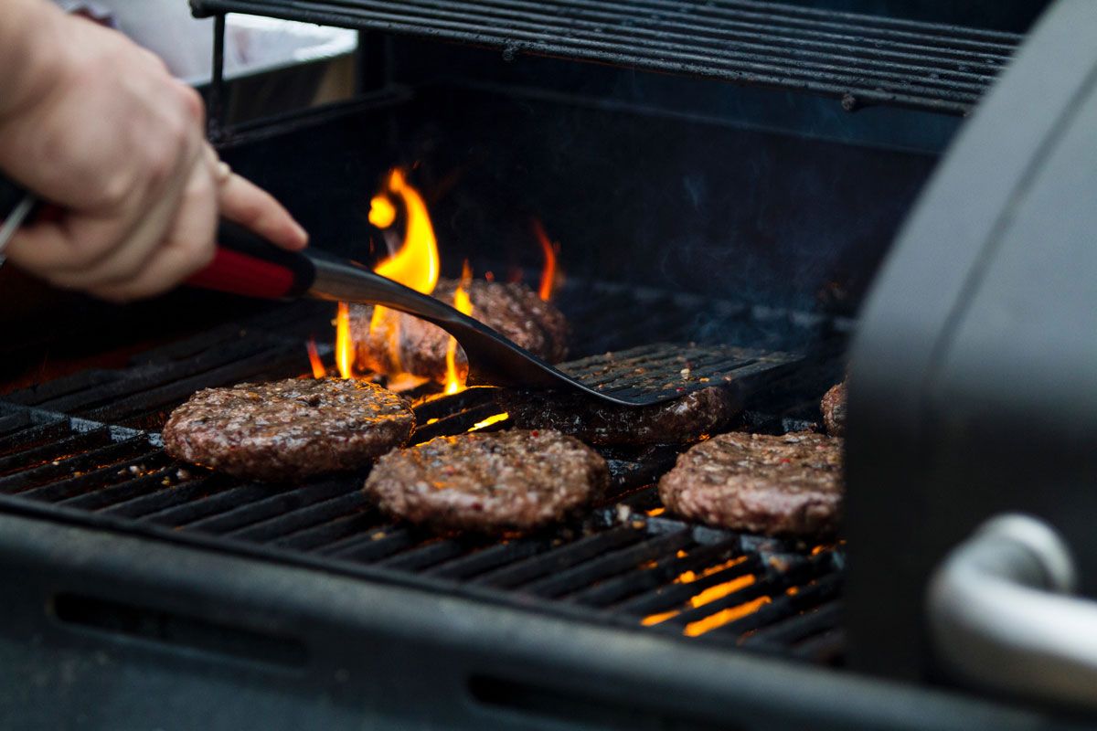 Image of someone grilling hamburgers